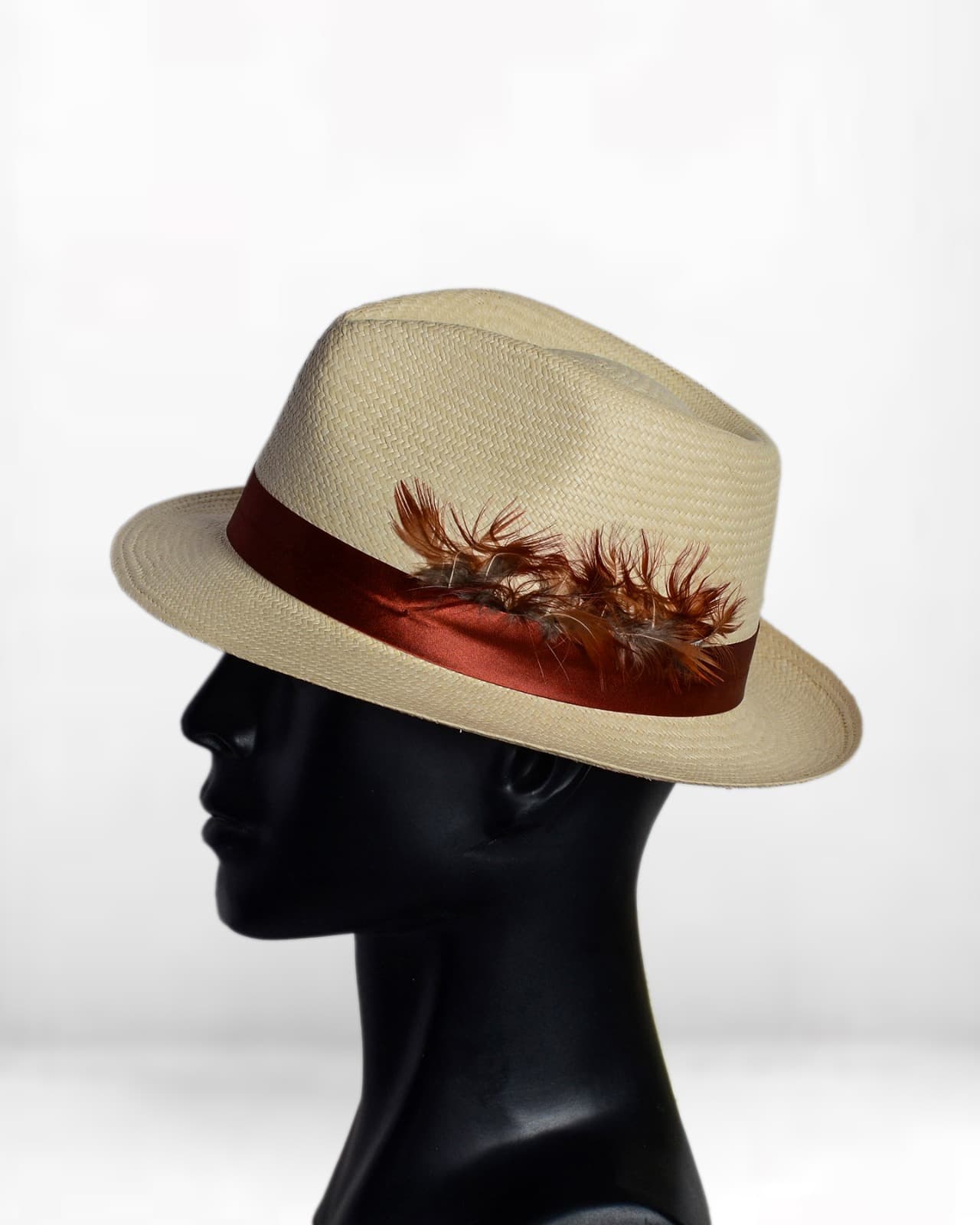 Cream woven hat with a brown band and feather detail